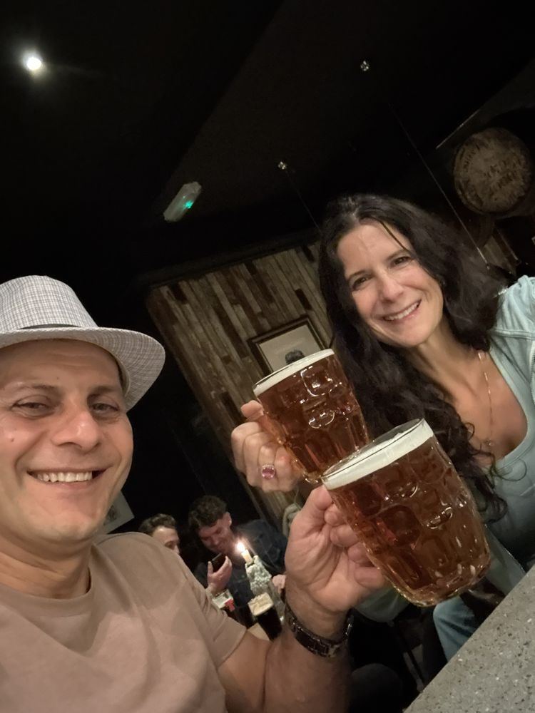 Rob and Nadine toasting pints in a pub