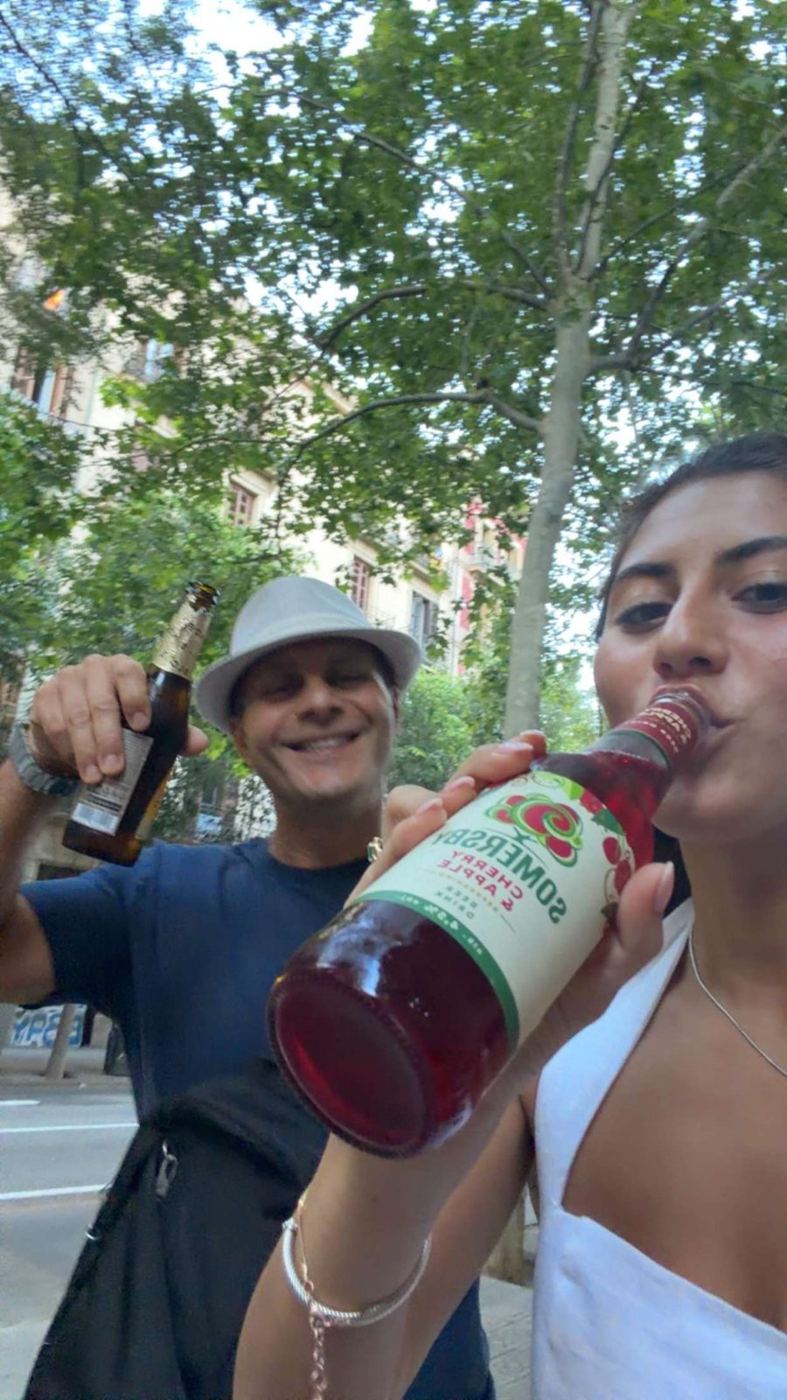 Rob and a friend with a bottle of sangria on a tree-lined street
